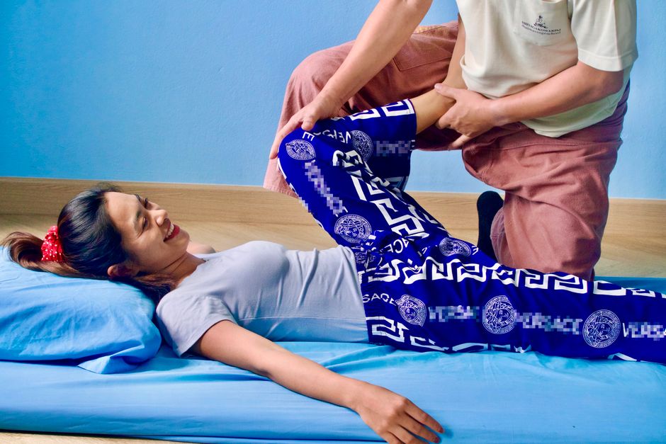 사람이 벽에 등을 대고 서서 벽 천사 스트레칭을 하는 모습, 바른 자세를 위한 스트레칭